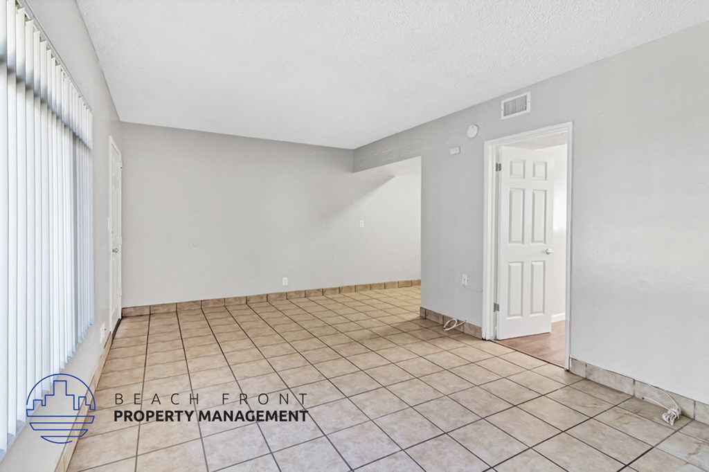 A room with a white door and tiled floor.